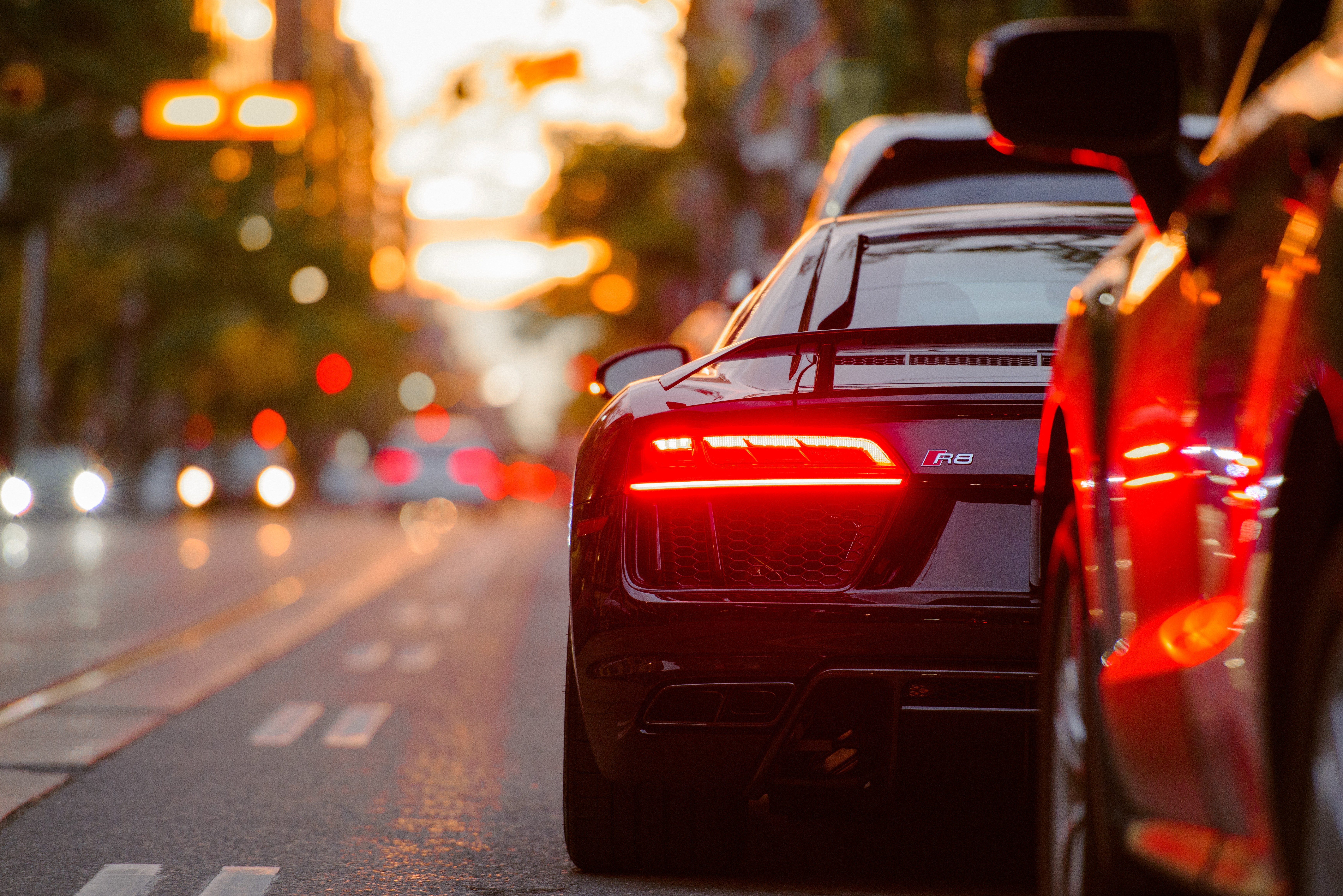 Left-side tail-lights of Audi R8 in traffic during sunset